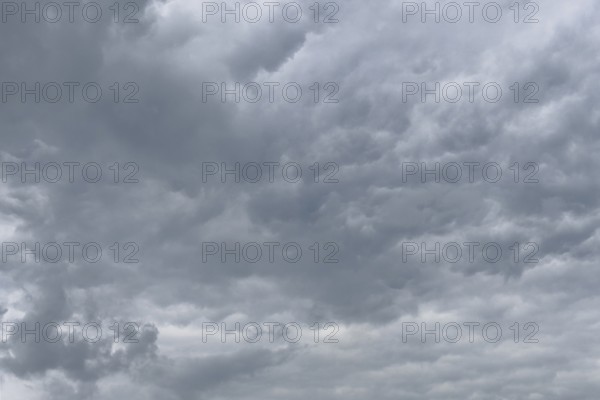 Grey cloud cover from Stratocumulus with bump-like bulges at the bottom unevenly marked by dents,
