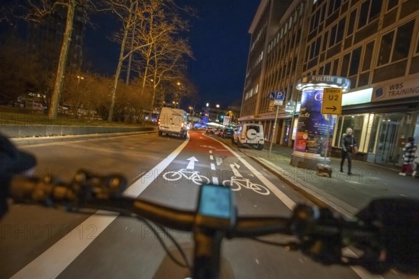 Cycling in the city, in the dark, in the evening, cycling on a bike lane, marked, Huyssenallee,
