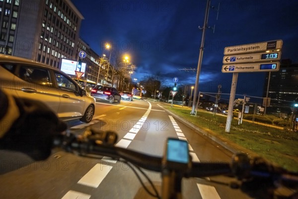 Cycling in the city, in the dark, in the evening, cycling on a bike lane, Huyssenallee, on