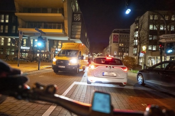 Cycling in the city, in the dark, in the evening, cycling on a bike lane, marked, between 2 lanes,
