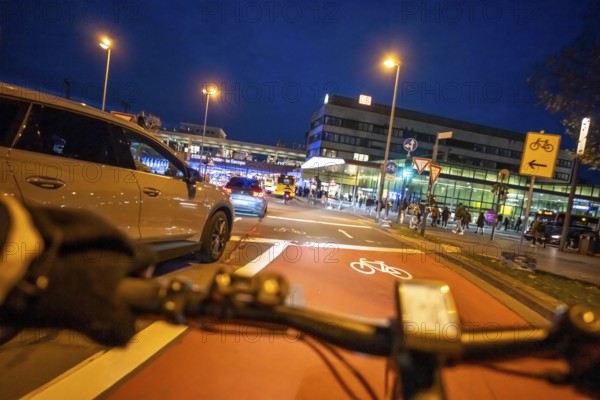 Cycling in the city, in the dark, in the evening, cycling on a bike lane, marked in red to alert