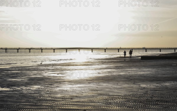 People on the beach at a pier, sunrise, Scharbeutz, 29.11.2025, Scharbeutz, Schleswig-Holstein,