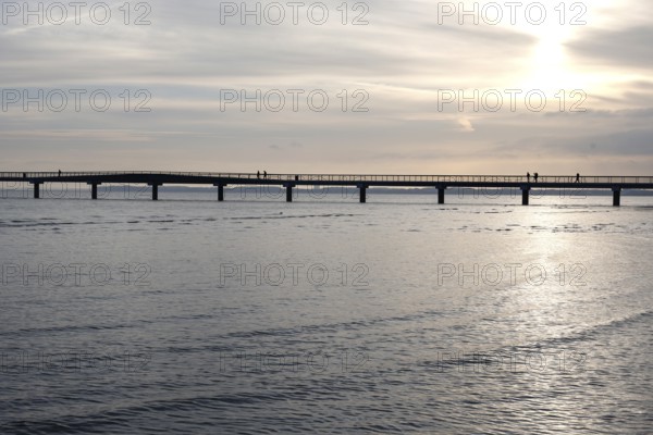 Silhouettes of people on a pier, sunrise, Scharbeutz, 29.11.2025, Scharbeutz, Schleswig-Holstein,