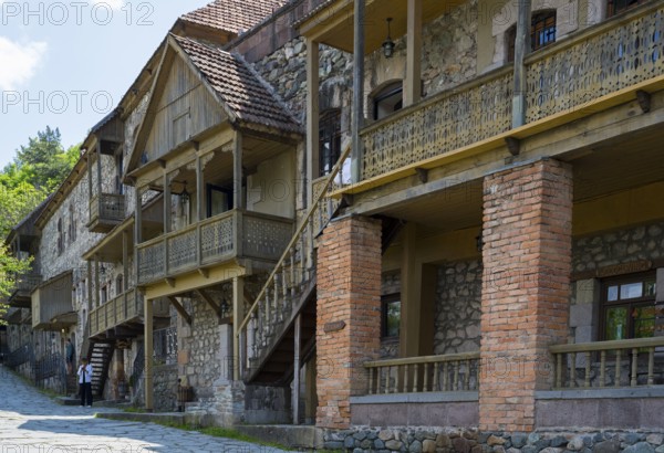 Row of old buildings with wooden verandas and brick walls on a cobblestone street in a quiet place,