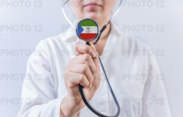 Female doctor holding stethoscope with Equatorial Guinea flag. National health system of Equatorial