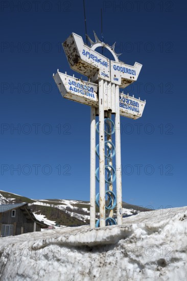 A sign in the snow at a mountain station under clear blue sky, Goderdzi Pass, Adjara region,