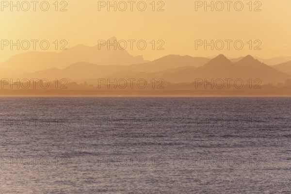 View of the ocean and Byron Bay hinterland at sunset. Mt. Warning, Wollumbin National Park over the