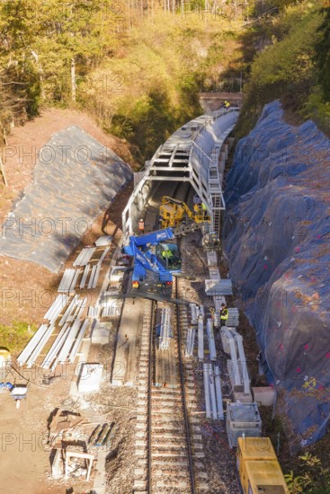 Railway tracks with crane and workers working on tunnels in autumn, Hermann Hesse Railway bat