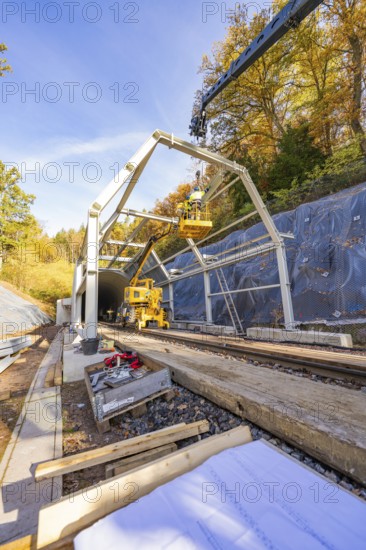 Construction plans and materials on a construction site where workers build metal structures,