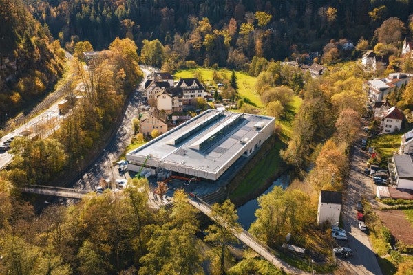 Building with solar panels in the middle of a picturesque autumn landscape with river and forest,
