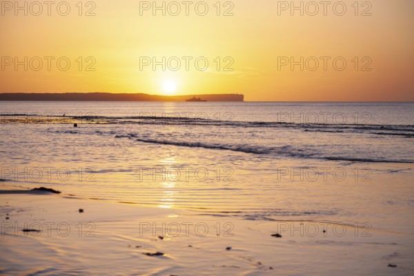 Sunrise over Jervis Bay â€” View of Point Perpendicular lighthouse. A ship on the horizon