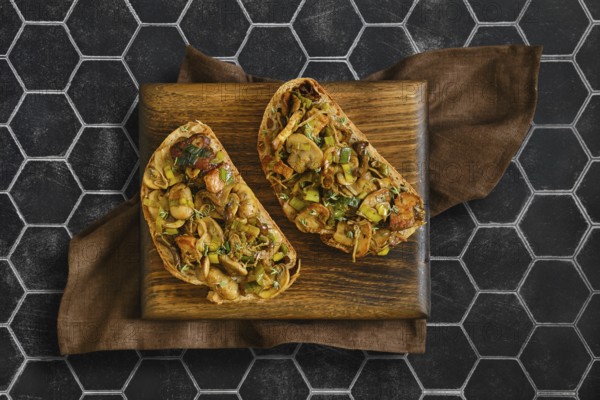 Two sandwiches with flavorful mix of honey mushrooms, enoki mushrooms, champignon, and leeks.