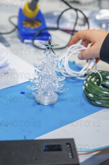 Small plastic Christmas tree on craft table with cable in hand, Jugend Forschungszentrum Nagold,