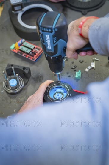 Person using a drill to assemble in a workshop environment, Jugend Forschungszentrum Nagold,