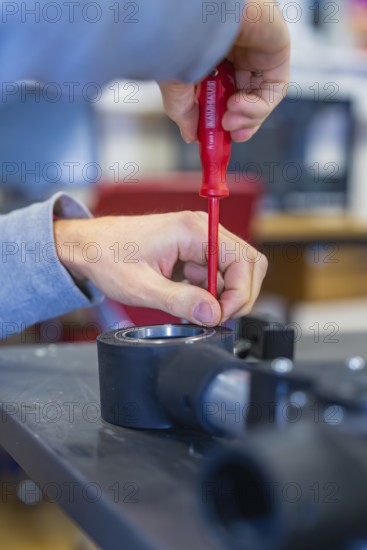 Person uses screwdriver to mount on a technical device, Jugend Forschungszentrum Nagold, Calw