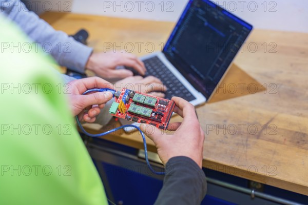 Circuit board is held while someone is working on a laptop, Jugend Forschungszentrum Nagold, Calw