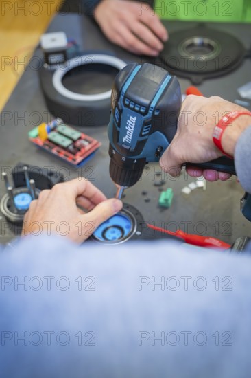 Person uses drills to secure components to a table, Jugend Forschungszentrum Nagold, Calw district,