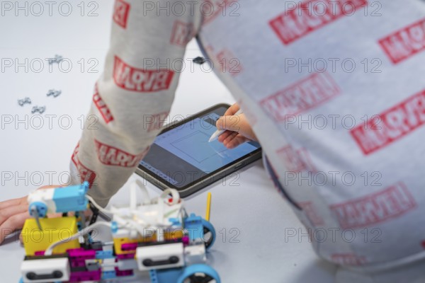 Child uses a tablet to control or design a robot, Jugend Forschungszentrum Nagold, Calw district,