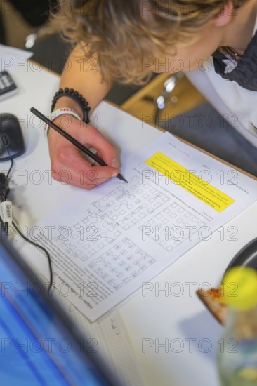 Young person working on math problems at a desk, Jugend Forschungszentrum Nagold, Calw district,