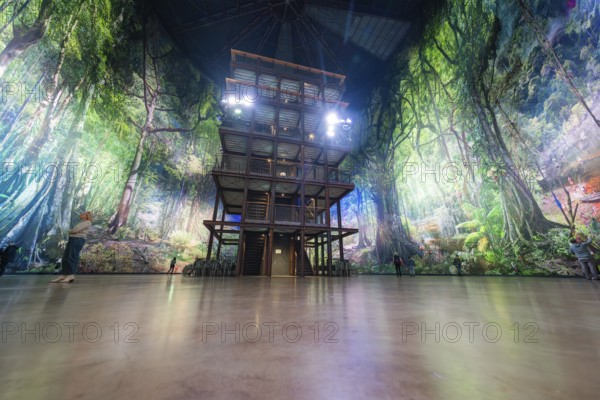 A multi-storey structure in a light-flooded artificial forest background, Amazonia exhibition,