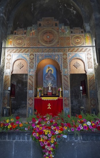 Artfully designed altar in a church, framed by colorful flowers and symbolic images, Sevanavank