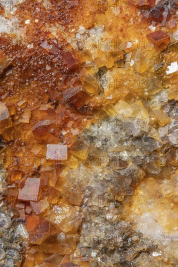 Shiny crystals of blue and orange color can be seen in this mineral formation. They are sparkling