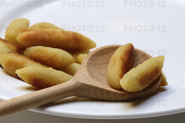 Fried puff noodles with cooking spoon on plate