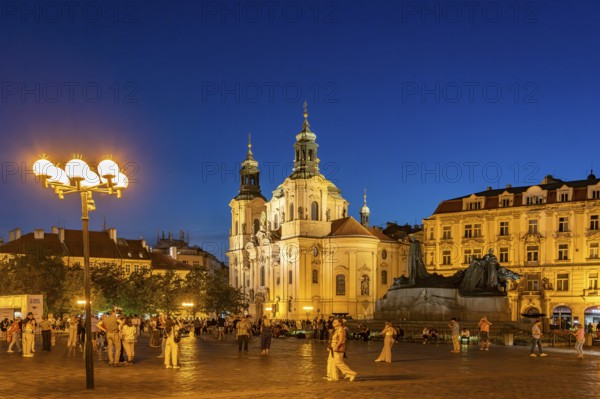 The Baroque St. Nicholas Church and the Jan Hus Memorial on Old Town Square at dusk, Prague, Czech