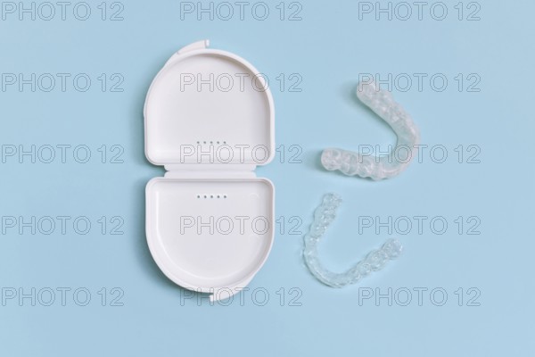 Customized transparent dental teeth bite guard clear aligners for lower jaw in white case on blue