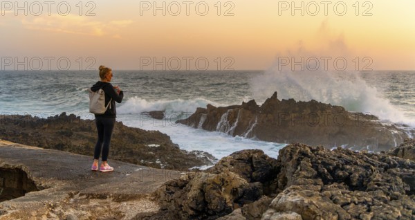 Young tourist standing on the coast of Farol de Cabo Raso lighthouse, SÃ£o Bras de Sanxete