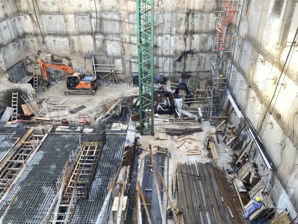 View of a construction site in a deep excavation pit, concrete work with lots of reinforcements,
