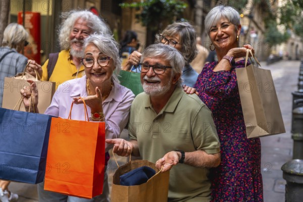 Happy group of smiling senior friends holding shopping bags while enjoying a leisure day out in the