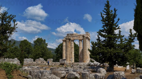 Ancient ruins of a temple surrounded by pine trees and bright blue sky, Ancient Sanctuary of Zeus,