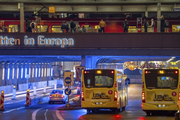 The main train station in Essen, blue illuminated underpass, bus station, am Europaplatz, train on