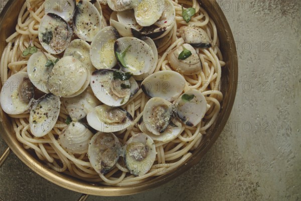 Spaghetti with vongole clams, in cream sauce, carbonara, in a brass pan, homemade, top view, no