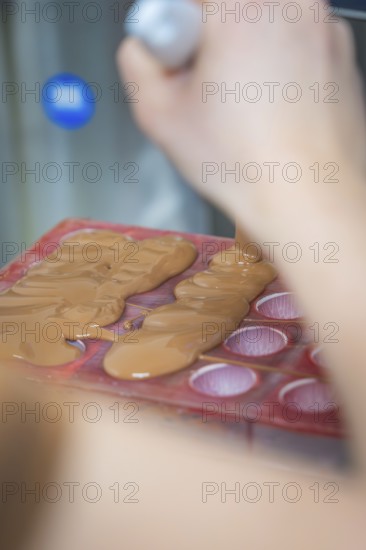 Close-up of liquid chocolate being poured into a chocolate mold, Christmas baking, Haselstaller