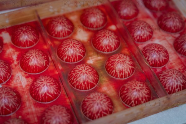 Close-up of red balls with white structures in a mold, Christmas baking, Haselstaller Hof,