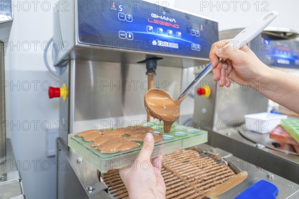 Chocolate is poured into molds from a machine with a ladle, Weihnachtsbacken, Haselstaller Hof,