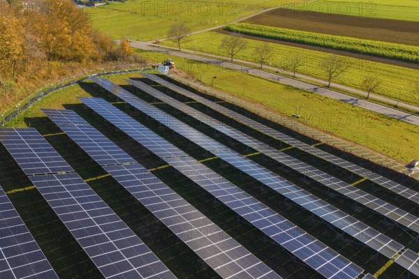 Field with solar panels shows use of technology nestled in autumn landscape, construction PV