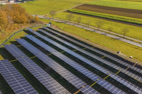 Solar modules in a structured arrangement from an aerial perspective, surrounded by green nature,