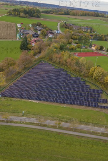 Extensive rural views with solar panels next to a small village, construction of a PV open-air