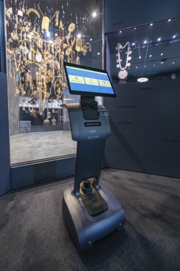 A robot in front of a glass display case full of jewelry in a dark exhibition area, robotic