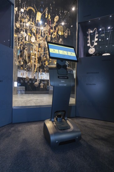 Robot with display stands in front of impressive jewelry exhibition in the museum, robot