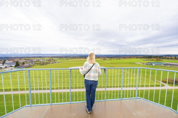 Woman standing on platform looking out over the vast landscape, DÃ¼rrenmettstetten observation