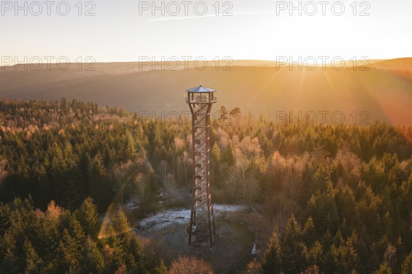 An observation tower stands in an autumnal forest at sunrise, Hohe Warte lookout tower, Hohenwart,