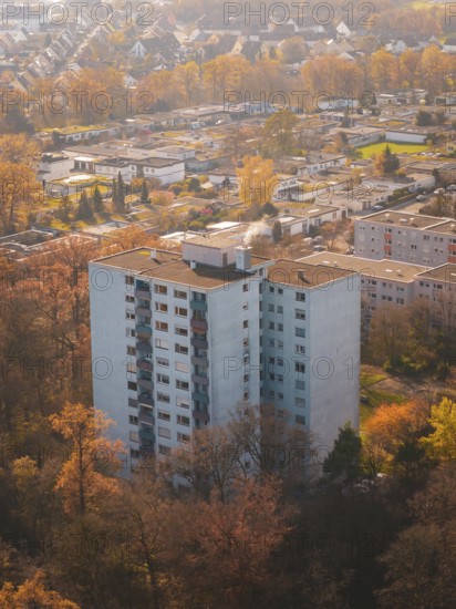 Large apartment block surrounded by autumn trees from above in an urban area, MÃ¼hlacker, Enzkreis,