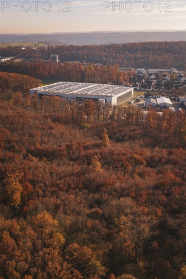 Factory building next to an autumn forest, with urban environment in the background, MÃ¼hlacker,