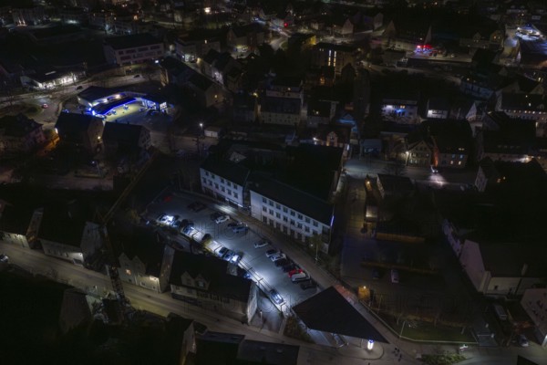 Nighttime view of city roads with parked cars and illuminated buildings, Nagold, Calw district,