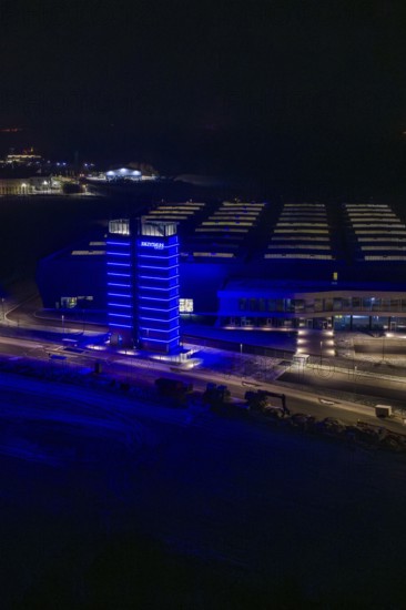 Night view of a factory with a blue illuminated tower in dark surroundings, Nagold, Calw district,
