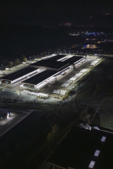 Night view of an industrial area with illuminated buildings and trucks, Nagold, Calw district,